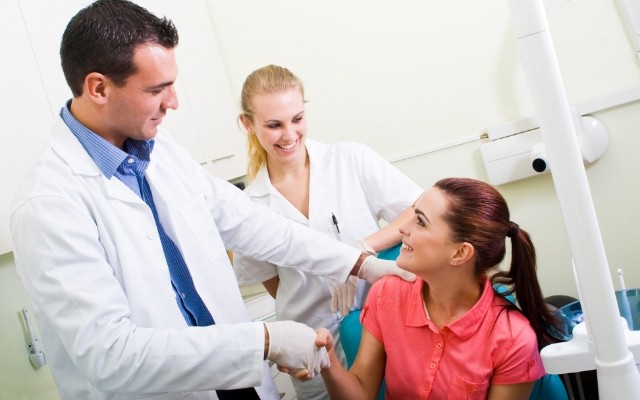 Dentist and dentistry team member talking to dental patient