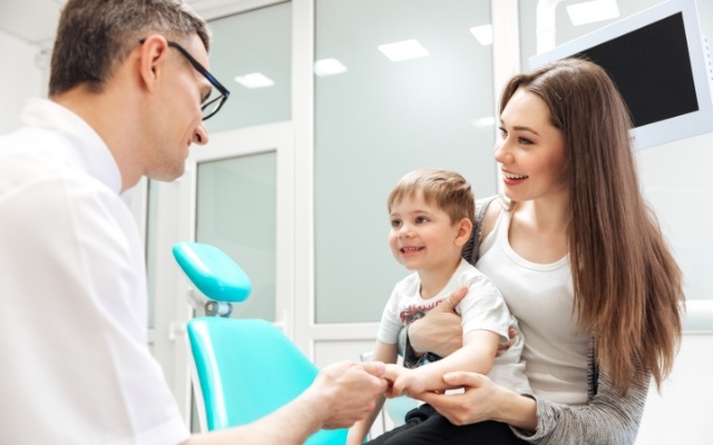 Dentist talking to mother and baby