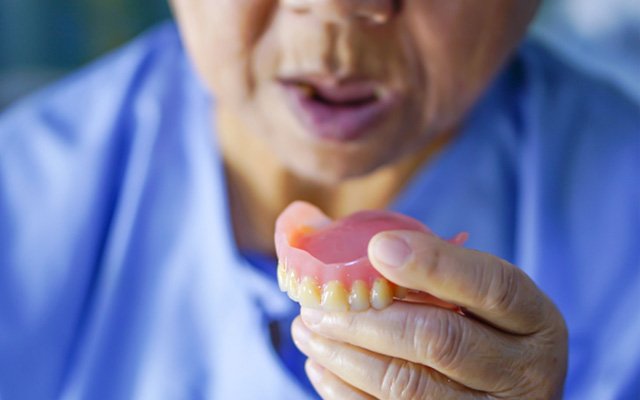 Man holding his upper denture 