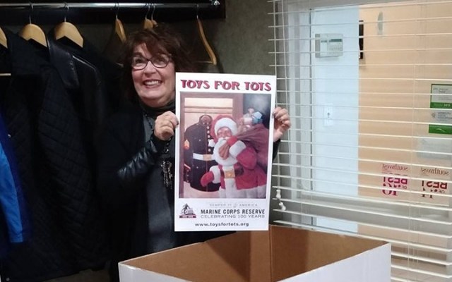 Dental team member holding a community event sign