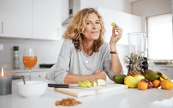 Middle-aged eating an apple and smiling
