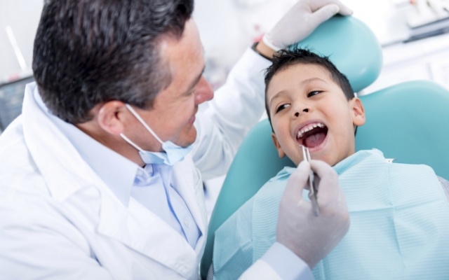 Dentist providing young child with a dental checkup