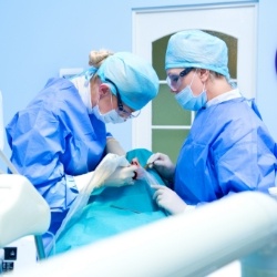 Dentist performing dental implant surgery