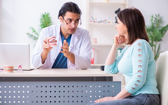 Dentist talking to female patient