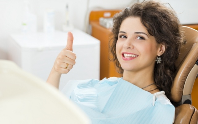 Woman giving thumbs up after full mouth reconstruction