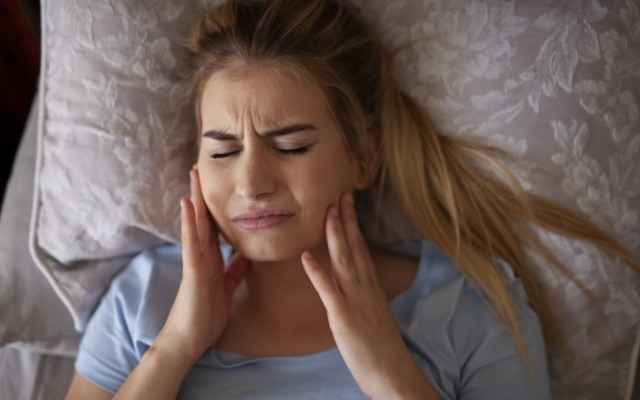 Woman in pain before using a nightguard for bruxism
