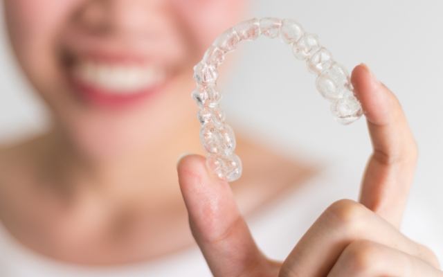 Person holding an Invisalign tray
