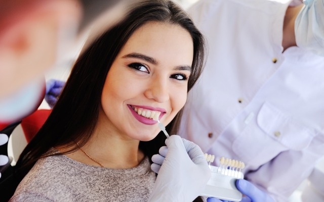 Woman's smile compared with veneers color option