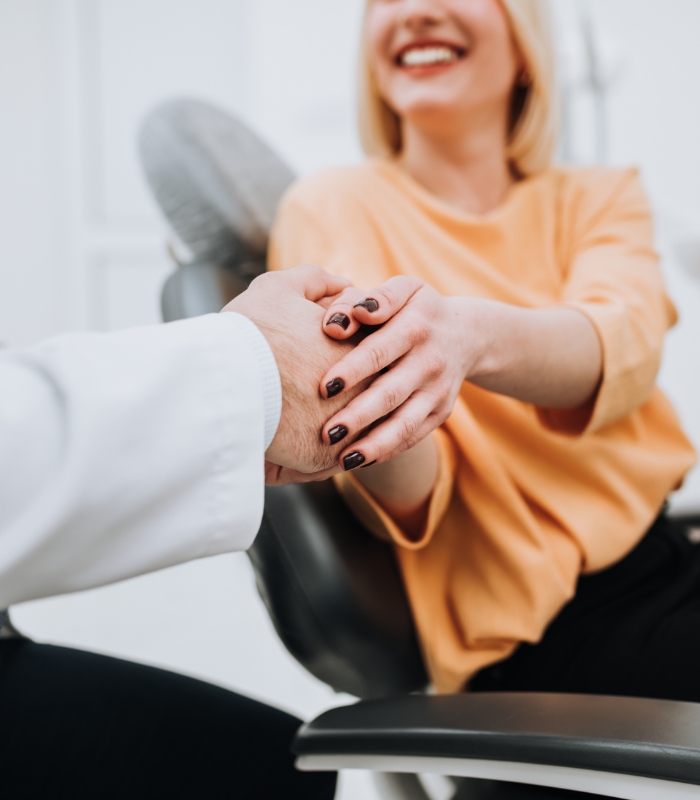 Smiling woman shaking hands with her dentist