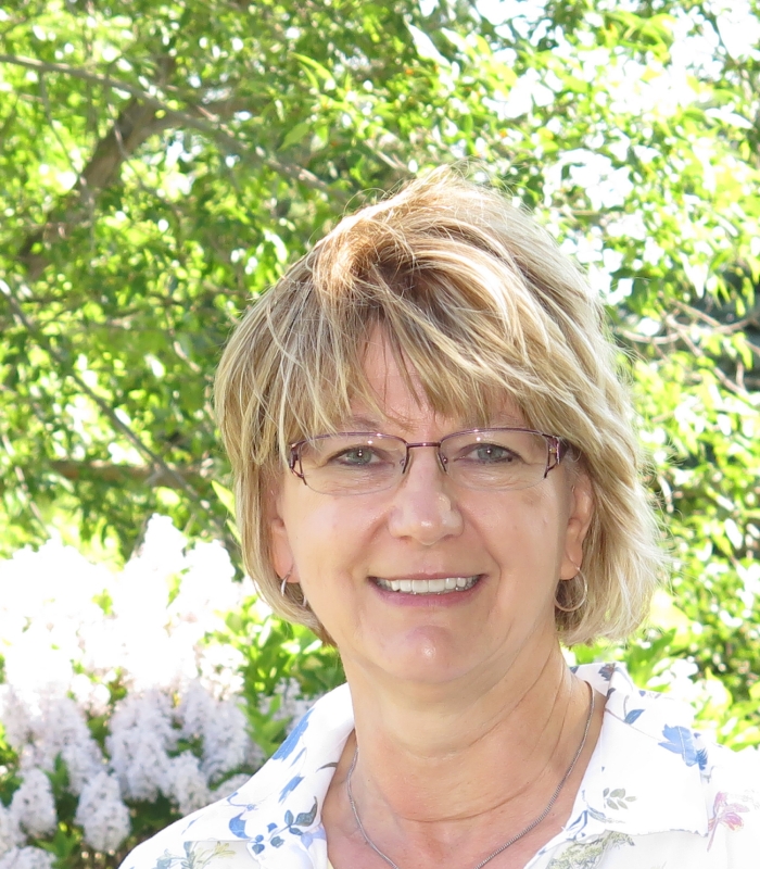 Woman with glasses smiling outdoors