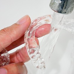 Person cleaning Invisalign trays