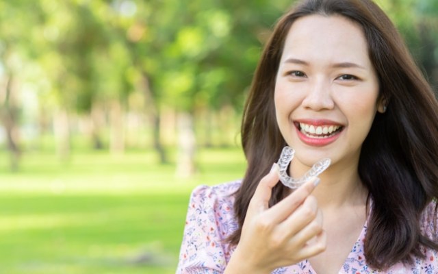 Woman placing an Invisalign tray