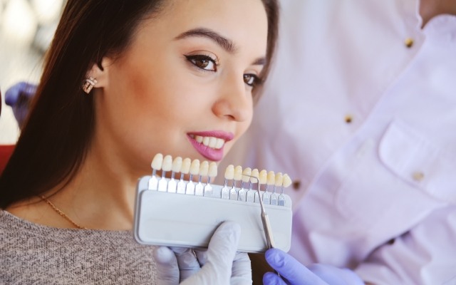 Woman's smile compared with veneers color option