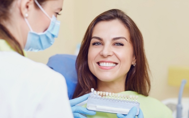 Woman's smile compared with veneer color options