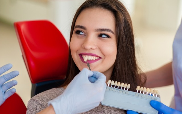 Dentist comparing smile to veneer shade option