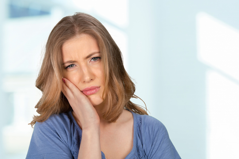 Portrait of young woman with toothache