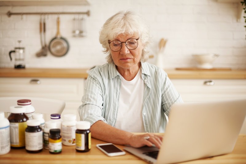 woman on computer looking at her medicine
