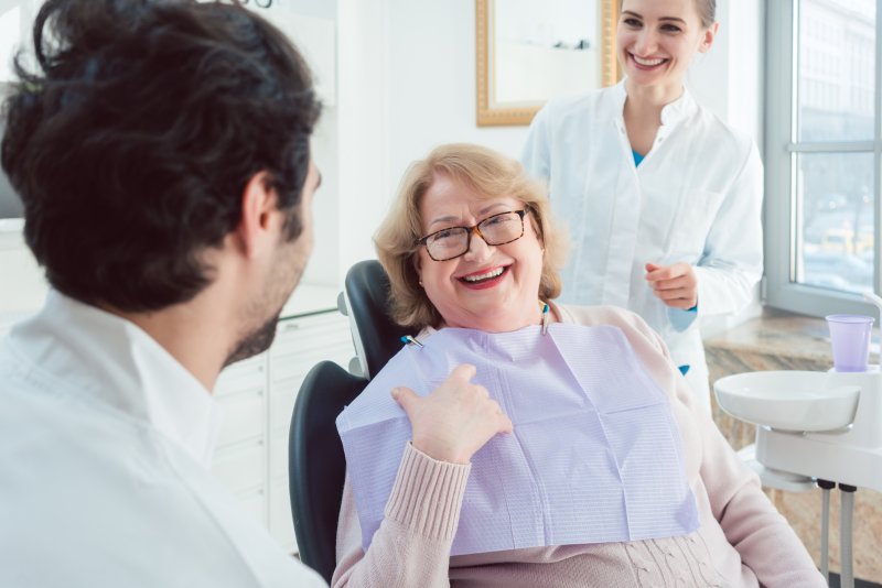 older woman smiling at dentist’s office 